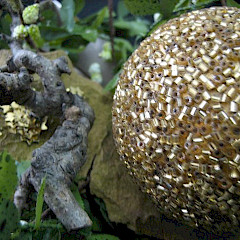 Detail mooi kerststukje, natuurlijke materialen en goudtinten.